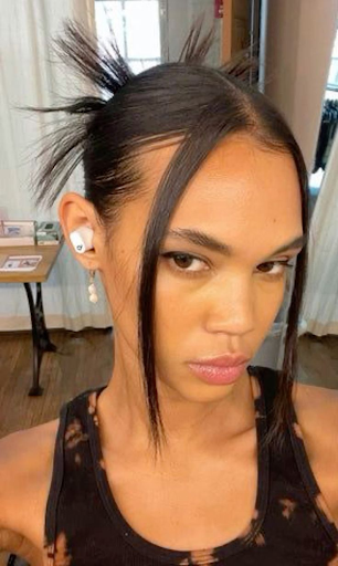A woman with a bold spiky bun hairstyle styled in a throwback Y2K aesthetic—capturing the playful, edgy vibe of early-2000s beauty trends making a modern comeback.