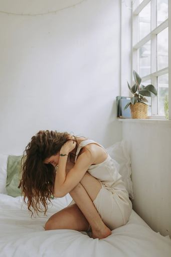 Girl on her bed with messy long brown hair that is matted. Taken from Pexels