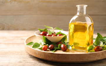 Image of a bottle of Jojoba on a wooden tray.