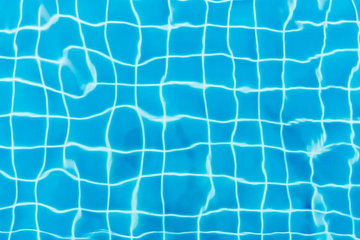 An abstract close-up shot of a swimming pool displaying the tile gridlines.