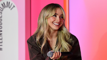 A smiling Sabrina Carpenter with fluffy bangs.
