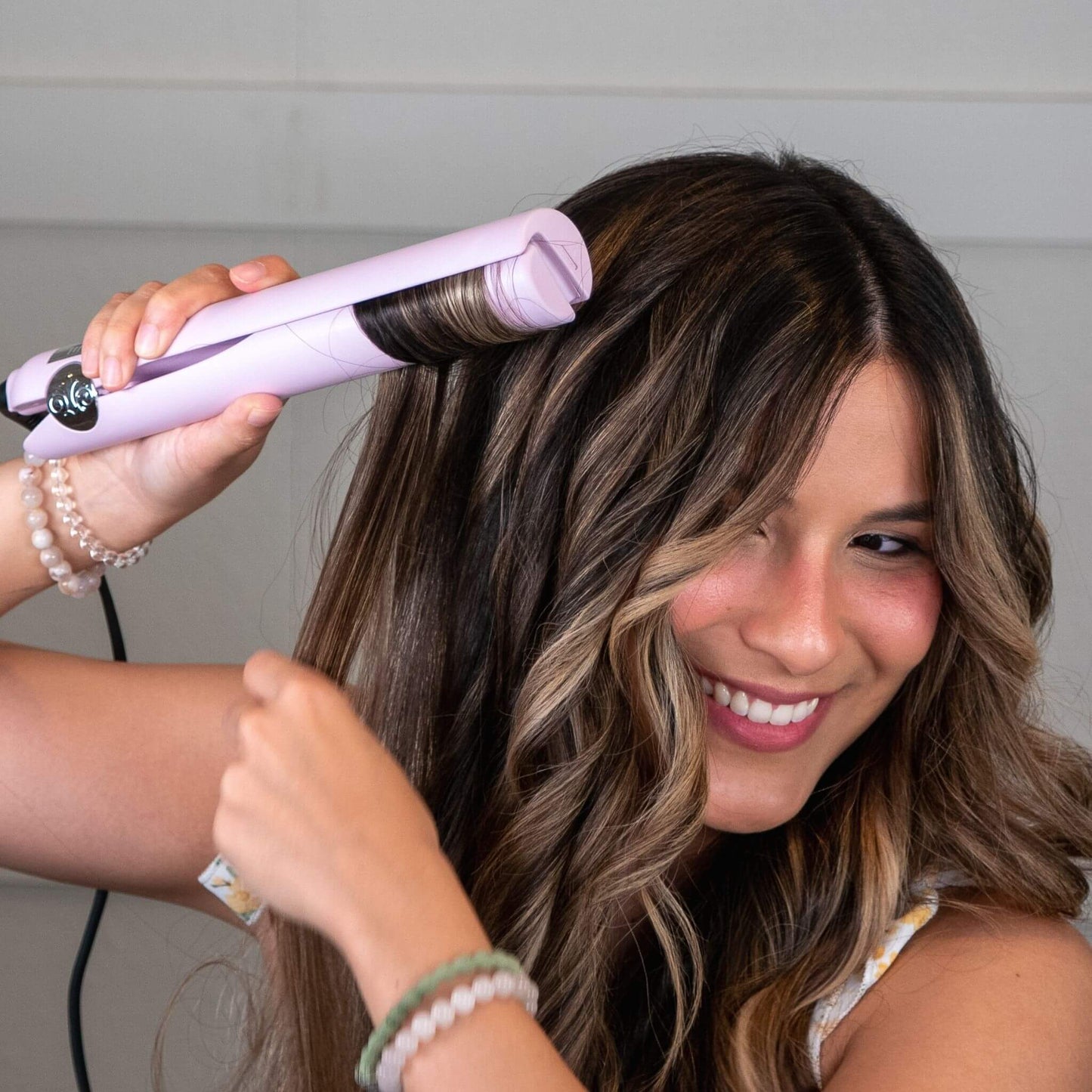 Brown haired woman curling with TYME Iron Pro: Aura.