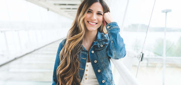 Woman with long brown/highlighted hair and big bouncey curls