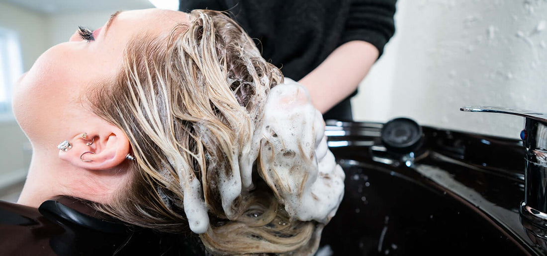 Blonde getting her hair shampooed 
