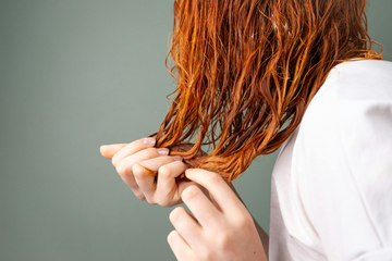 Image of a girl tousling her hair wet after showering.
