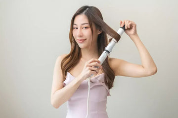 Woman curling her brown hair