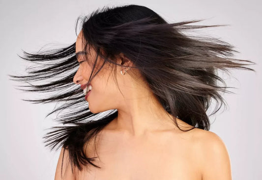 A woman shows off her hair with natural movement, bouncy and shiny.
