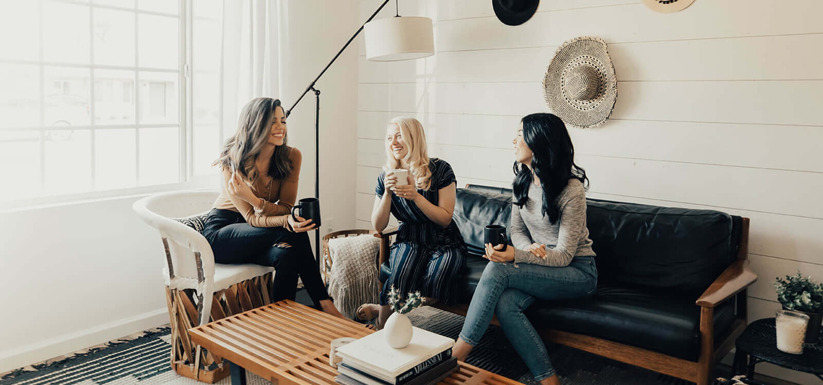 Three women sitting in a living room having a discussion.