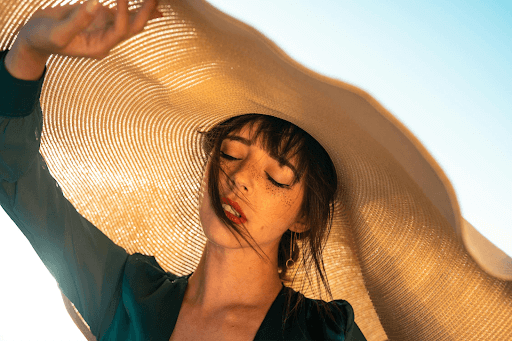 (Girl in the sun wearing a hat with a chocolate brown cool summer hair color idea. Taken from Pexels) 