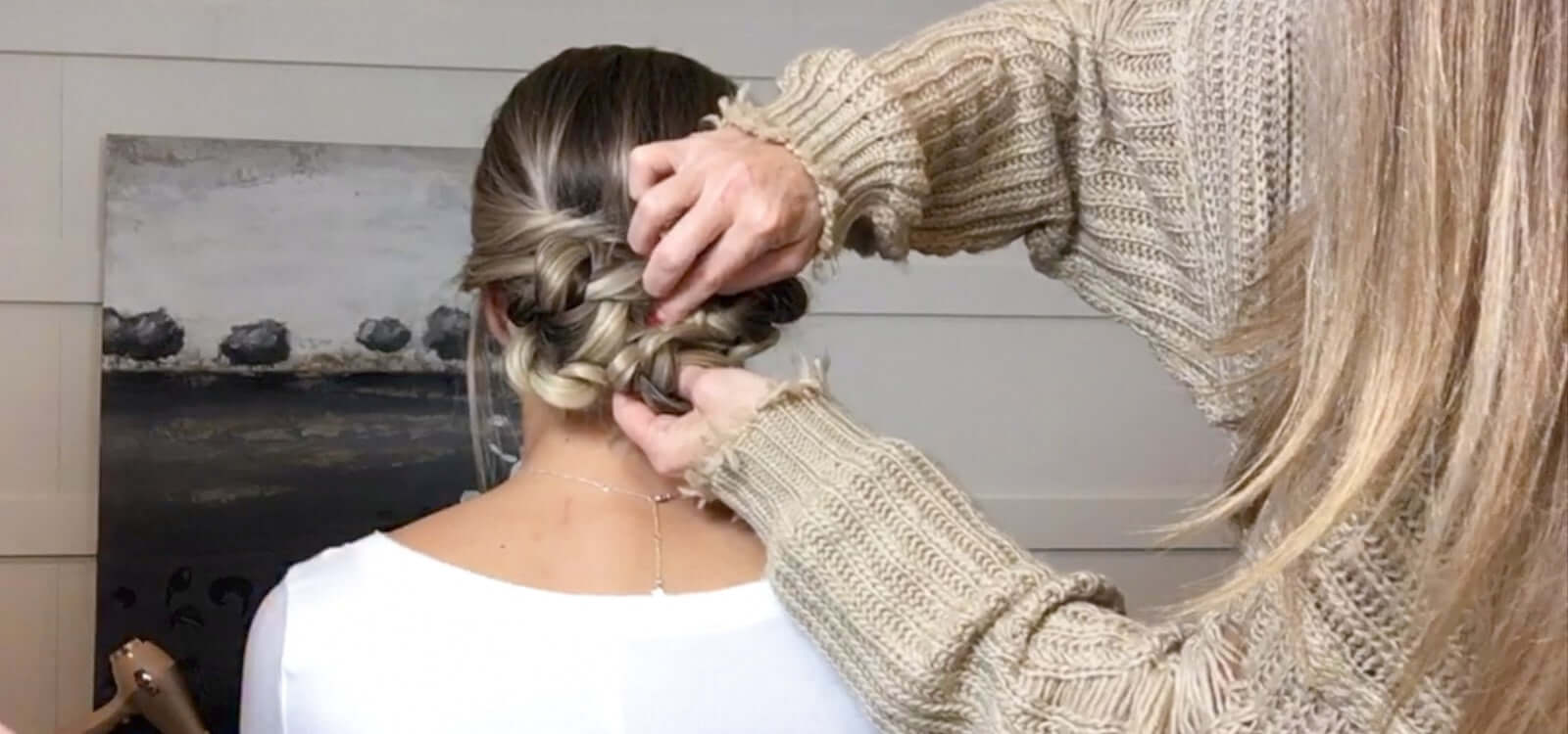 lady styling an easy braided holiday updo on her friend