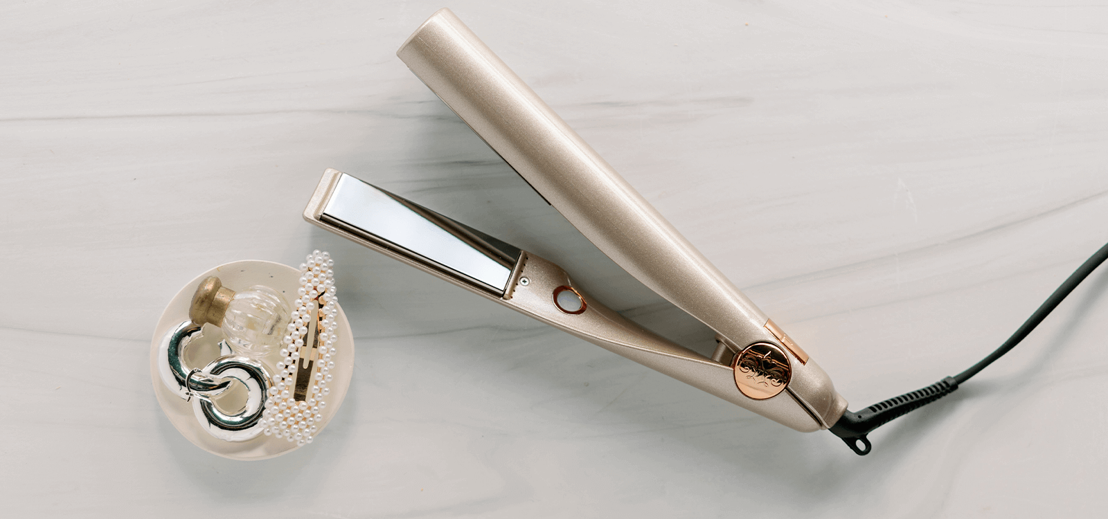 A rose gold TYME Iron Pro resting on a marble table. 