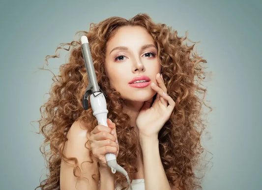 Woman with big curly hair holding curling iron