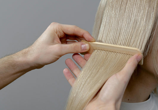 Image of a woman having her blonde hair combed.
