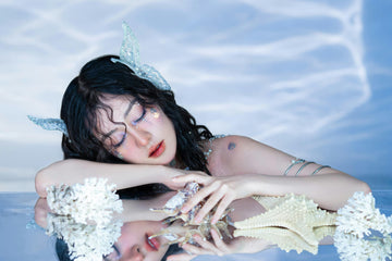 A young woman dressed as a mermaid, surrounded by marine decorations.