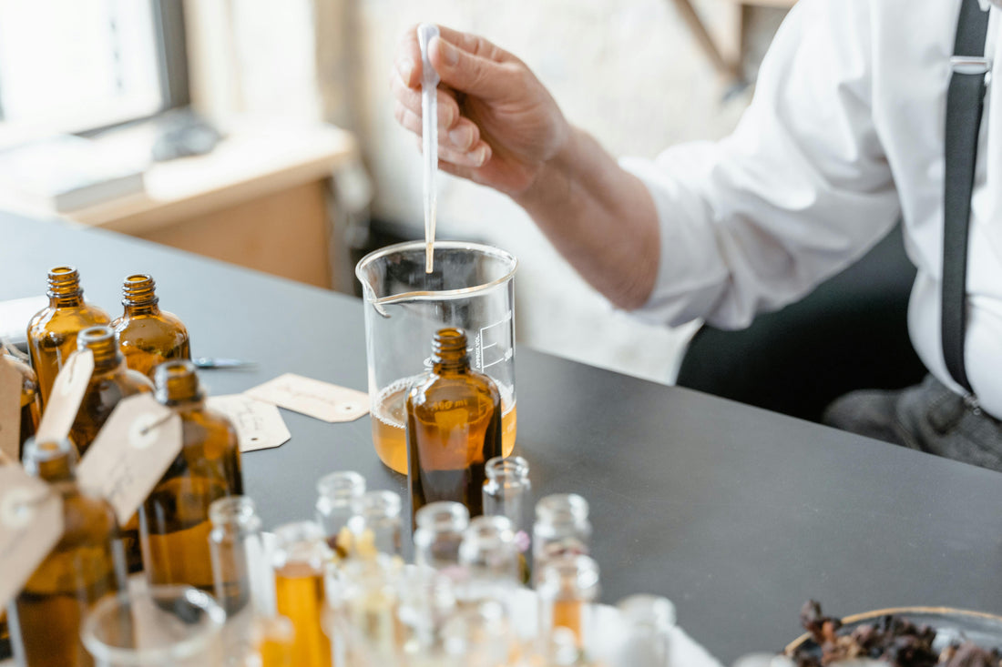 A person mixing hair oils with a pipette in a workshop.