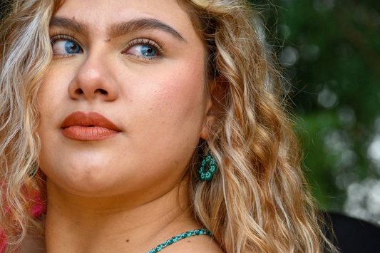 A close-up of a young woman with blonde wavy hair.