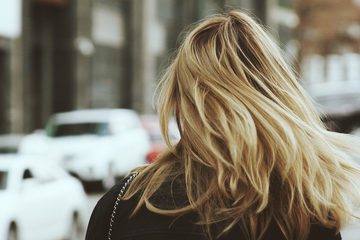 Image of the back of a lady's head with blonde hair.