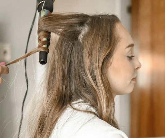 Image of a girl getting her hair curled.