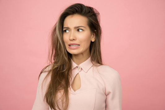 Image of a girl with long hair against a pink background.