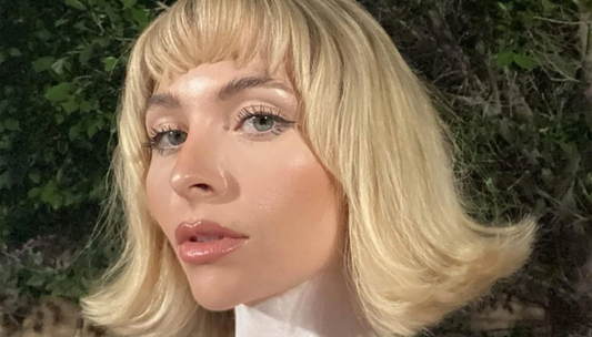 Image of a girl with voluminous blonde hair with flicked out ends. 