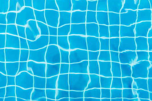 An abstract close-up shot of a swimming pool displaying the tile gridlines.