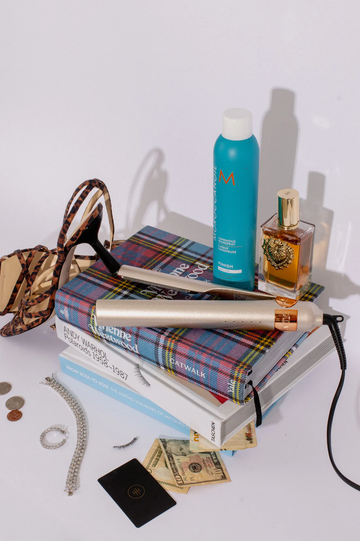 Image of Tyme Iron Pro on a pile of books with Moroccan Oil.