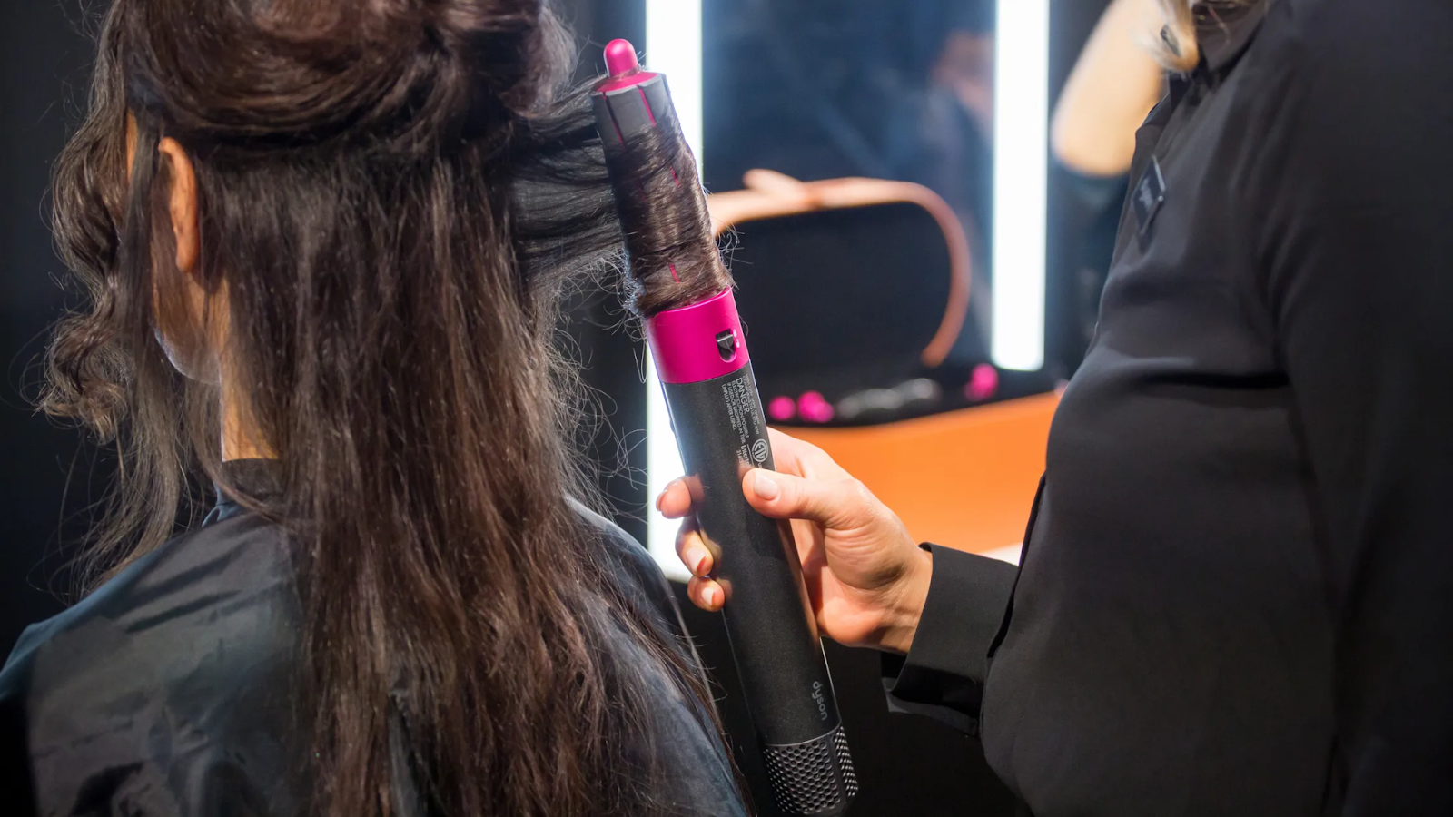 Image of a girl having her hair curled with the Dyson Airwrap.