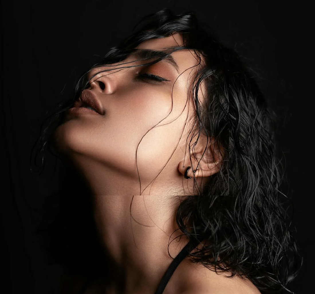 Image of a lady with her hair tilted back with short hair. 