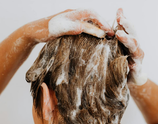 Image of a woman washing her hair in the shower.