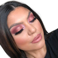 Woman with black shoulder-length hair wearing rose gold eyeshadow and fake eyelashes