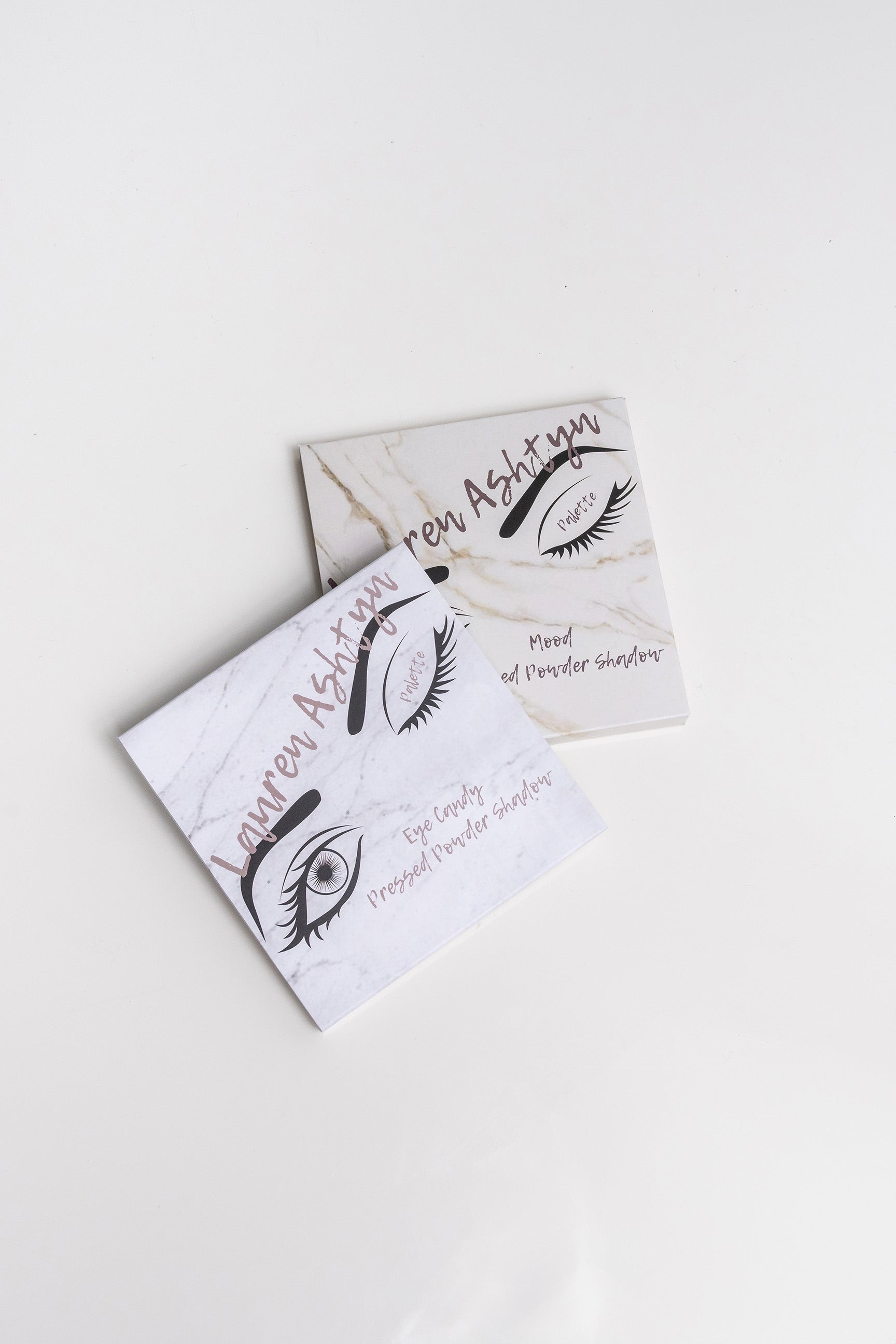 Lauren Ashtyn "eye candy" eye shadow box next to the "mood" eye shadow box. The boxes have an image of a woman's eyes on them.