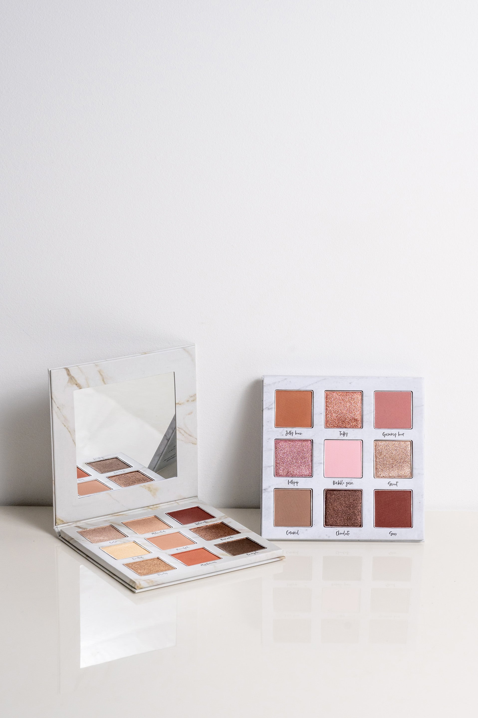 Lauren Ashtyn "mood" eye shadow palette with attached mirror open. To the right, the "eye candy" palette is leaned upright.  