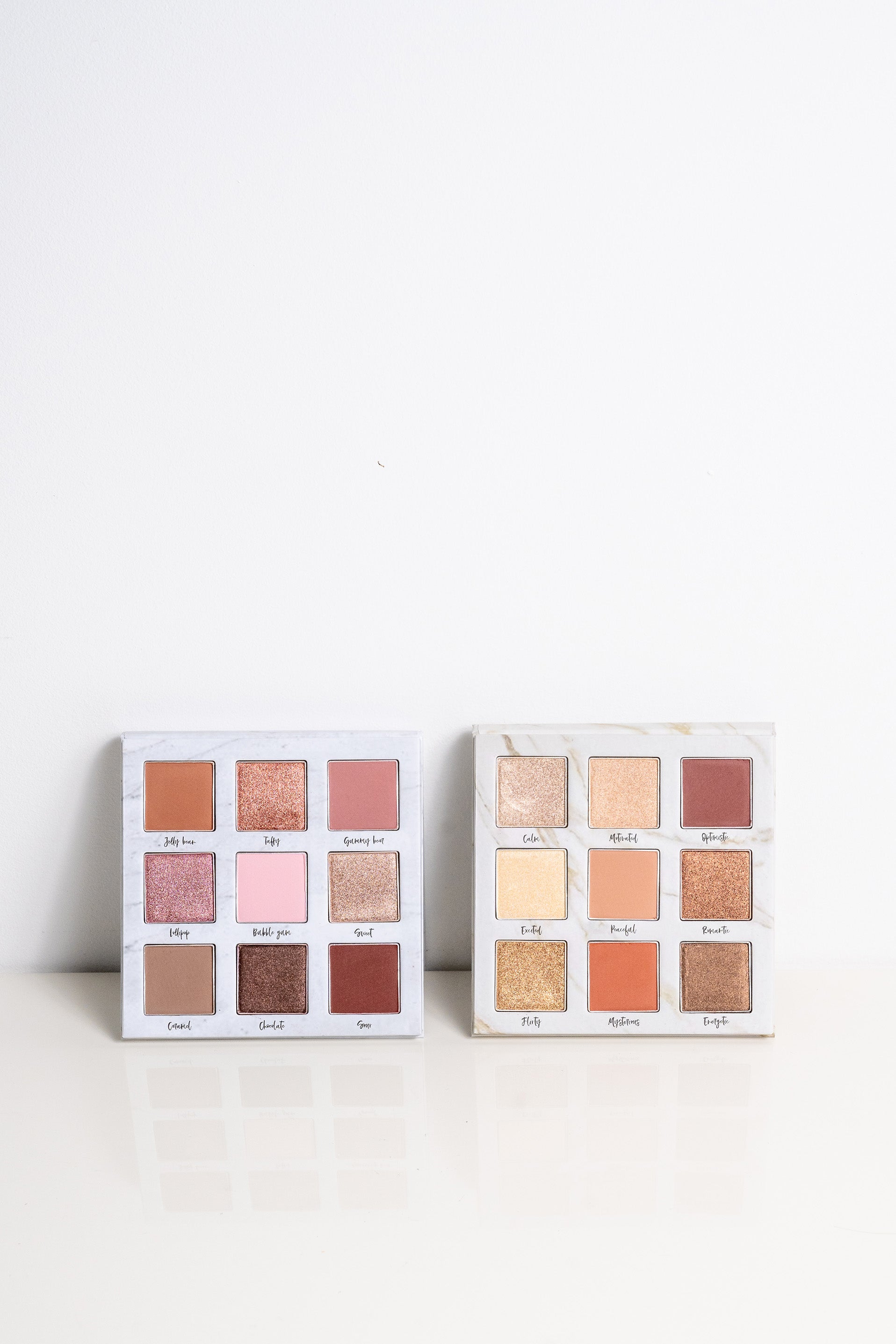 Lauren Ashtyn "eye candy" pressed powder eye shadow palette next to the "mood" eye shadow palette. 