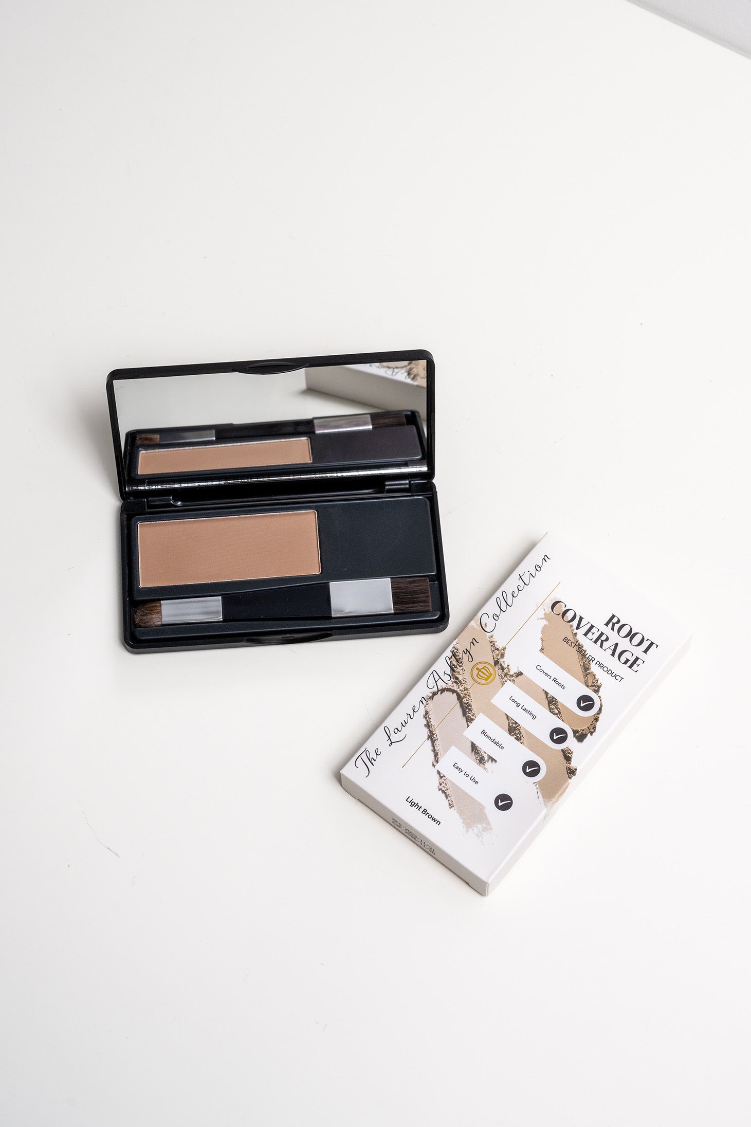 Open palette of light brown root coverage powder by Lauren Ashtyn with attached mirror and brush included