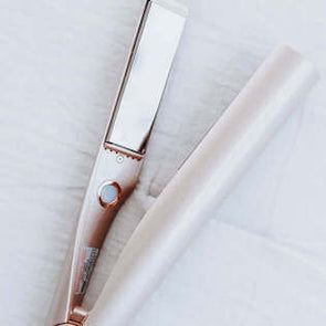 TYME Iron Pro rose gold edition on a white fabric background.