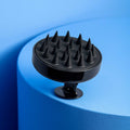 TYME Shampoo brush sitting on blue background.