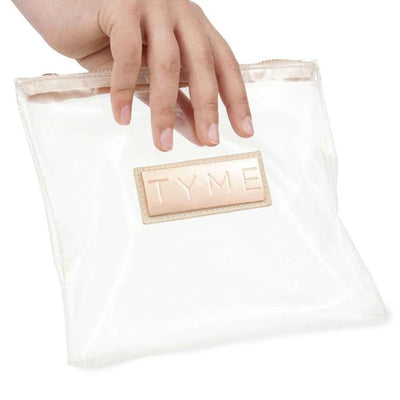 Small zippered clear product travel bag with TYME name on the front on a rose gold emblem.