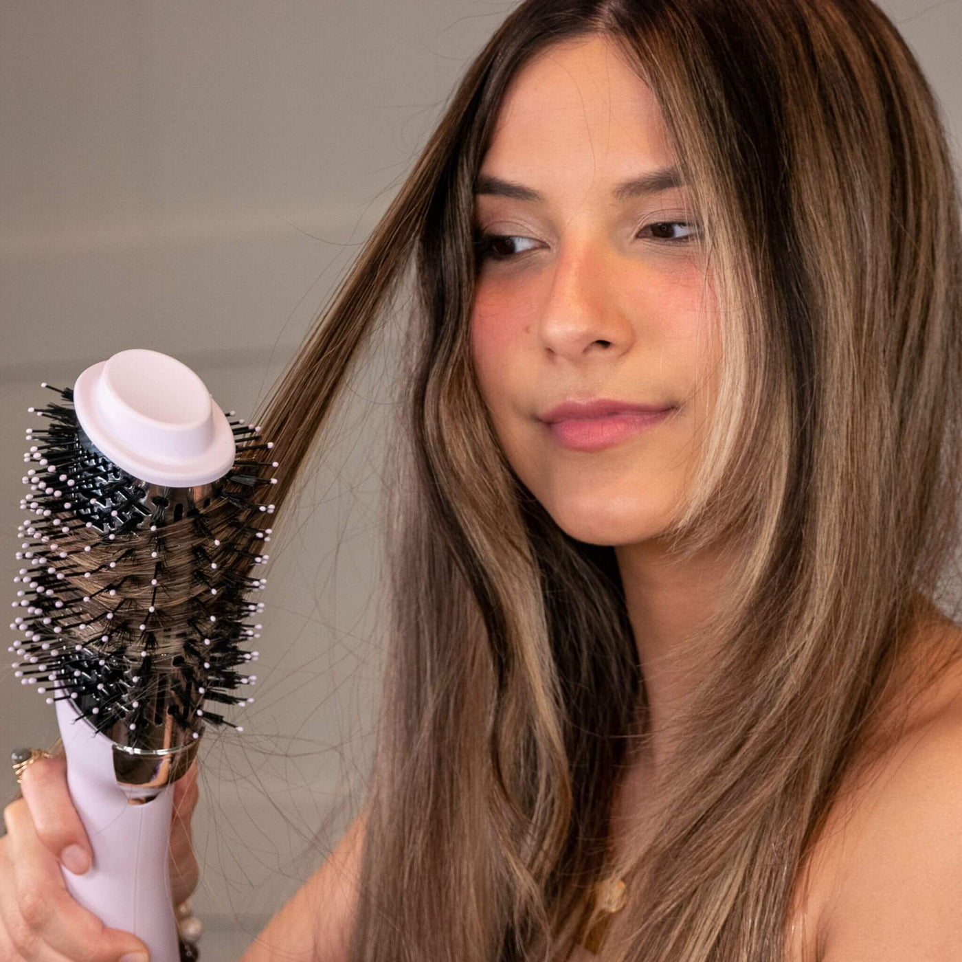 Brown haired woman using the TYME BlowBrush Aura.